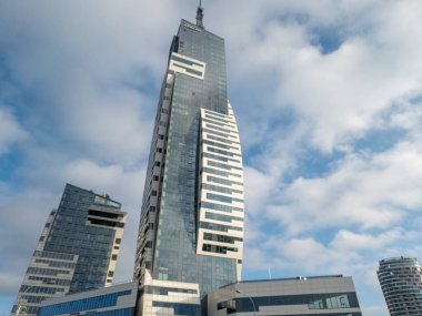 Rzeszow Polonya - 19 Aralık 2025: Modern gökdelenler iş ve seyahat reklamcılığı için ideal bir şehir ortamında çağdaş mimari sergilenen bulutlu bir gökyüzüne karşı dimdik duruyorlar.