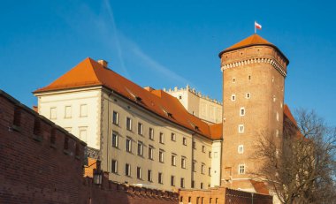 Krakow Polonya - 17 Şubat 2019: Polonya mirası ve kültürünü temsil eden açık mavi gökyüzüne karşı Gotik ve Rönesans mimarisinin bir karışımını barındıran tarihi Wawel Kalesi.