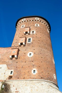 Krakow Polonya - 17 Şubat 2019: Ortaçağ mimarisi ve tuğla yapısını gözler önüne seren canlı mavi gökyüzüne karşı tarihi Wawel Kalesi 'nin yakın görüntüsü.