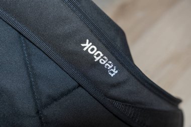 Varşova Polonya - 20 Aralık 2025: Reebok logosuna yakın plan siyah kumaş kaplama markası ve spor malzemeleri. Spor tanıtım fitness reklamı veya pazarlama için ideal.