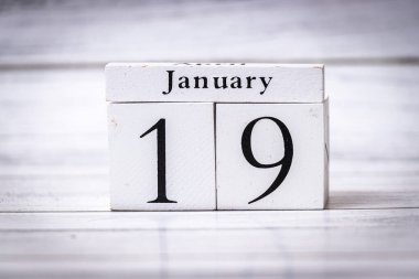 Tarihi 19 Ocak olarak gösteren ahşap bir takvim bloğu. Bu fotoğraf zaman yönetimi organizasyonunun özünü ve editoryal kullanım için uygun planlamayı yakalar..
