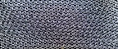 Benzersiz altıgen desenlere sahip siyah bir ağ kumaşının yakından görüntüsü. Yapı, giysi ve aksesuarlar için uygun hafif ve solunabilir bir doku sunuyor..