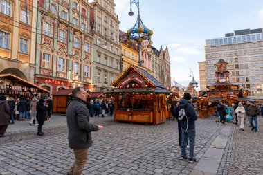 Wroclaw Polonya - 3 Ocak 2026: Canlı Noel Pazarı, renkli süslemeler arasında gezen ve ilgi çeken insanların güzel dekore edilmiş tezgahlarını sergiliyor ve festival atmosferi yaratıyor.