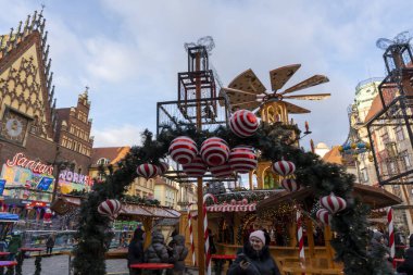 Wroclaw Polonya - 3 Ocak 2026: Wroclaw 'daki neşeli Noel pazarını renkli dekorasyonlar aydınlatıyor. Ziyaretçiler canlı atmosferin keyfini çıkarıyorlar. Yiyecek ve tatil neşesi karışımı sergiliyorlar..