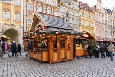 Wroclaw Polonya - 3 Ocak 2026: Tarihi mimari eserleri satın alan ziyaretçilerle dolu bir Noel pazarı sahnesi için dekore edilmiş büyüleyici bir ahşap tezgah.