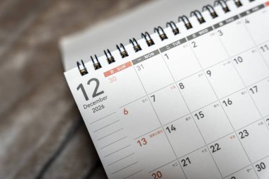 Close-up of a desk calendar page displaying December 2026 with highlighted dates and a spiral binding. Ideal for planning organization and time management promotions.