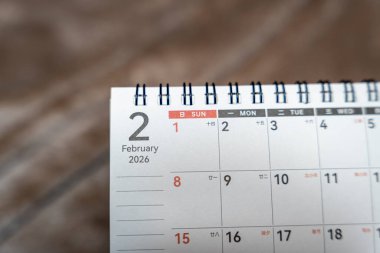 Işıklandırılmış güneş ve tarih 1 ile Şubat 2026 tarihli spiral takvimin yakın çekimi. İş ve kişisel bağlamlarda görsel planlama ve programlama için ideal.