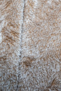 Sıcak bej tonlarda yumuşak desenli kumaşın yakın çekim görüntüsü. Moda tasarımı için ideal ev dekorasyonu veya yaşam tarzı pazarlaması konfor ve stil uyandırmak için ideal.