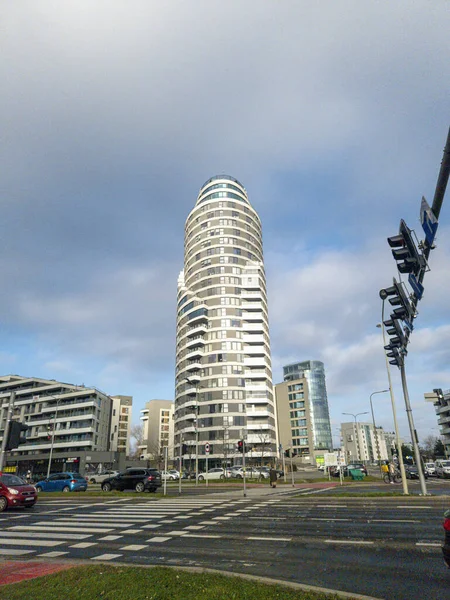 Rzeszow Polonya - 19 Aralık 2025: Çeşitli dükkanlarla çevrili uzun silindirik bir konut binası ve kentsel bir ortamda karışık kullanımlı gelişim içeren modern kentsel mimari.