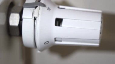 Radyatör termostatını elle çevirerek ısıtma seviyesini düşürür ve ev enerjisinden tasarruf ederiz..