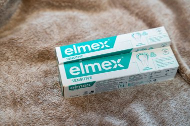 Varşova Polonya - 29 Ocak 2026: Yumuşak bej bir yüzeye yerleştirilmiş iki tüp elmex hassas diş macunu diş bakımı ve ağız temizliğini vurguluyor.