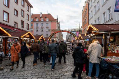 Wroclaw Polonya - 3 Ocak 2026: Wroclaw 'daki işlek sokak piyasa sahnesi çeşitli tezgahlar içeriyor. Kalabalık alışveriş yapıyor ve geleneksel el sanatları ve mevsimlik dekorasyonları keşfediyor..