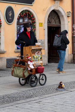 Wroclaw Polonya - 3 Ocak 2026: Sokak sanatçısı, kalabalık bir şehir sahnesinde kültürel canlılığı artıran bir varil org gösterisi yapıyor.