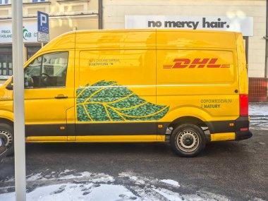 Rzeszow Polonya - 6 Ocak 2026: Çevre dostu taşımacılığı temsil eden yeşil yapraklı sarı bir DHL dağıtım minibüsü.