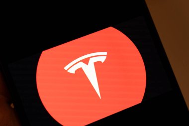 Varşova Polonya - 5 Şubat 2026: Elektrikli araçlardaki yenilik ve teknolojiyi vurgulayan canlı kırmızı bir arka plan karşısında Tesla logosunun belirgin bir şekilde sergilenmesi.