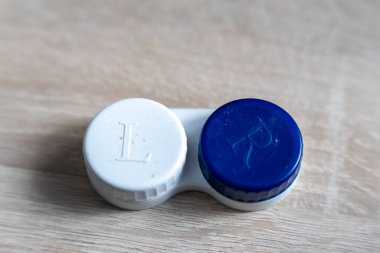 Göz bakımı gereksinimleri yakın planda gösteriliyor. Renkli kaplamalı lens kılıfı, L ve R etiketli. Organizasyon ve kişisel hijyeni vurguluyor..