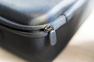 Karmaşık fermuar mekanizmasını ve dayanıklı malzemeyi vurgulayan siyah desenli bir fermuar kılıfının yakın çekimi. Çeşitli ortamlarda seyahat veya organizasyon amacıyla ideal.