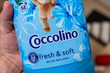 Varşova Polonya - 24 Şubat 2026: Çiçek tasarımı ve pazarlama ve evde bakım promosyonu için uygun mavi sıçrama özgeçmişi içeren Coccolino kumaş yumuşatıcı şişesi.