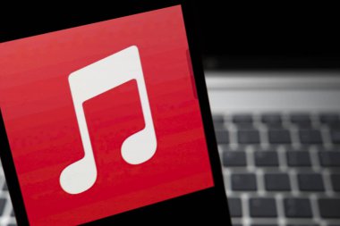 Varşova Polonya - 24 Şubat 2026: Parlak bir kırmızı müzik notası simgesi, müzik ve ses hizmetlerini sembolize eden zıt bir koyu arkaplan karşısında belirgin bir şekilde sergilenmektedir.