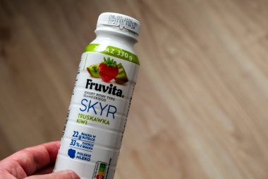 Varşova Polonya - 26 Şubat 2026: Çilek ve kivi aromalı plastik bir şişede meyveli yoğurt tutan bir el sağlık odaklı tüketiciler için ideal.