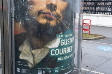 Viyana - 21 Şubat 2026: Gustave Courbet sergisi için bir reklam bir otobüs durağında sergilendi. Poster, Courbet 'in gerçekçilikteki önemini vurguluyor..
