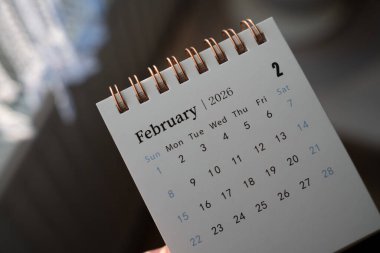 Şubat 2026 'yı altı çizili tarihlerle gösteren spiral takvim sayfasının yakın çekimi. Kişisel veya iş ortamlarında planlama ve planlama amaçları için ideal.