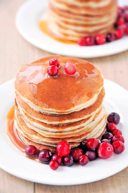 Karamel soslu ve böğürtlenli lezzetli krepler. Beyaz tabak. Tahta masa. Karamel şurubu. İki kişilik kahvaltı. Günaydın.