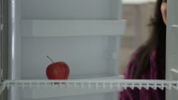 Mujer tomando manzana de la nevera — Vídeos de Stock