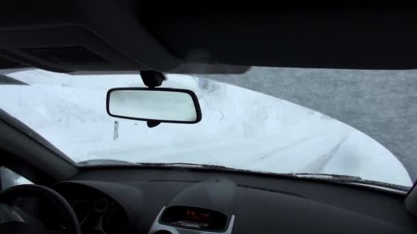 Vista desde el asiento delantero del coche en la carretera cubierta de nieve — Vídeo de stock