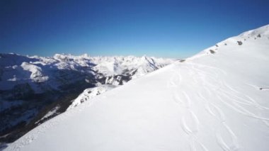 Mavi gökyüzü, karla kaplı kret üzerinde uçan