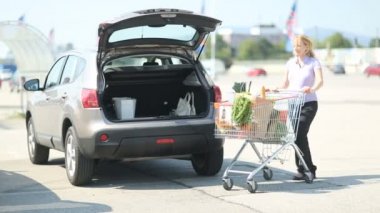 hamile kadın şeyler arabaya koyarak