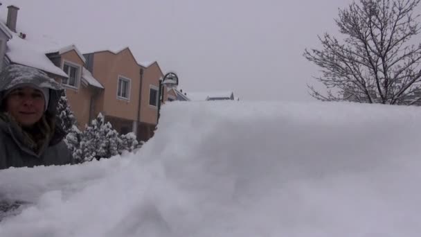 Женщина выметает снег из своей машины — стоковое видео