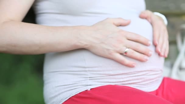 Vrouw aanraken van haar zwangere buik — Stockvideo