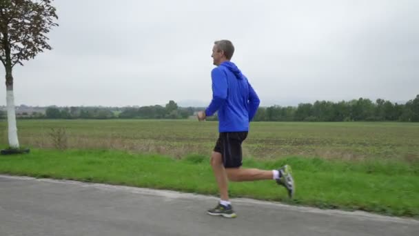 Mann joggt an bewölkten Tagen in Zeitlupe — Stockvideo