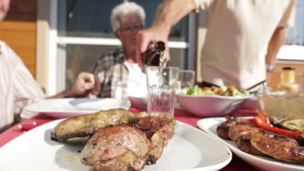 Senioren aan barbecue tafel met bier — Stockvideo