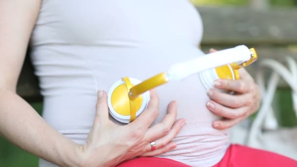 Gravid kvinna sitter på parkbänk — Stockvideo