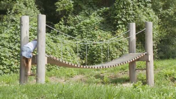 Chica en puente de tablón — Vídeo de stock