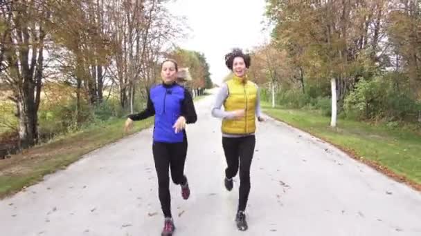 Duas mulheres correndo no outono — Vídeo de Stock