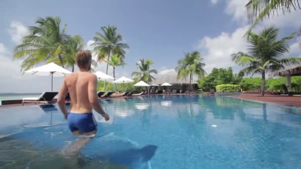 Young man taking swimming in pool — стоковое видео