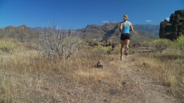 Femeie alergând pe platoul stâncos — Videoclip de stoc