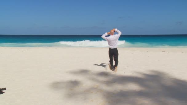 Zakenman uitkleden aan zandstrand — Stockvideo