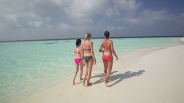 Kumsalda yürüyen kadınlar