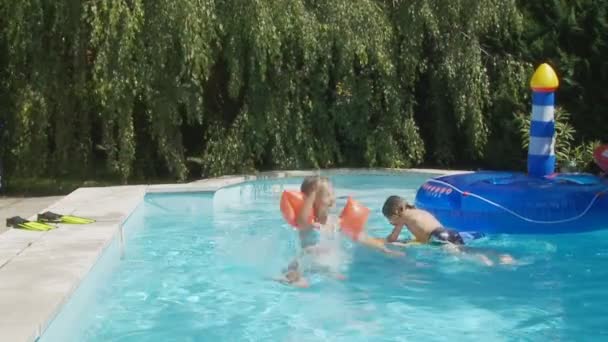 Junge und Mädchen springen in Schwimmbad — Stockvideo