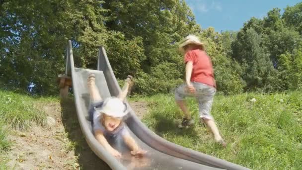 Little girl and boy sliding — Stock Video