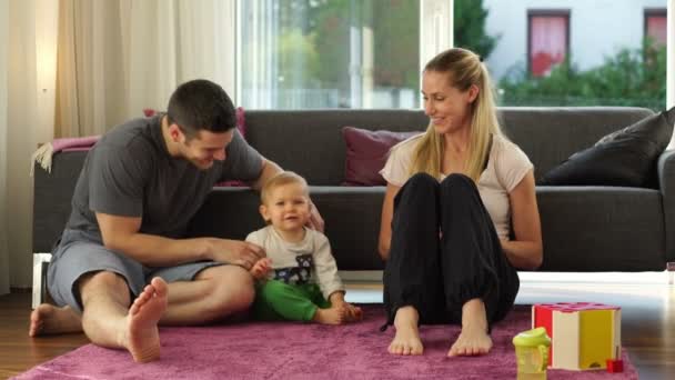 Jonge familie ontspannen in de woonkamer — Stockvideo