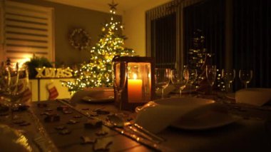 4k görüntü, yavaş doli Noel arifesi için dekore edilmiş yemek masasını yeni evin oturma odasında yeni bir Noel ağacı ve süsleme ile birlikte yeni Atom Shogun ile yakalandı.