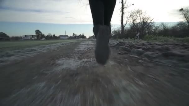 Женщина бежит по снежной дороге — стоковое видео