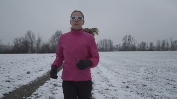 Γυναίκα που τρέχει σε χιονισμένο δρόμο — Αρχείο Βίντεο