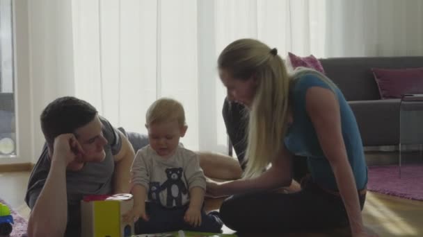 Jeune famille jouant sur le sol à la maison — Video