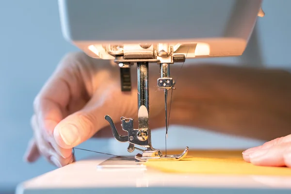 Women's hands at work with the sewing machine — Stock Photo, Image